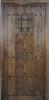 Puerta rústica exterior de tablas y ventanuco con reja.